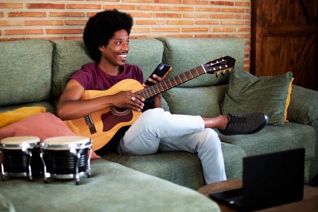 Foto gratuita adolescente de tiro completo haciendo música en casa
