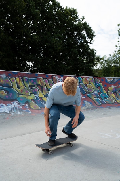 Foto gratuita adolescente de tiro completo en patineta al aire libre