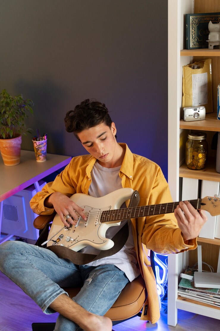 Foto gratuito adolescente de tiro completo tocando la guitarra