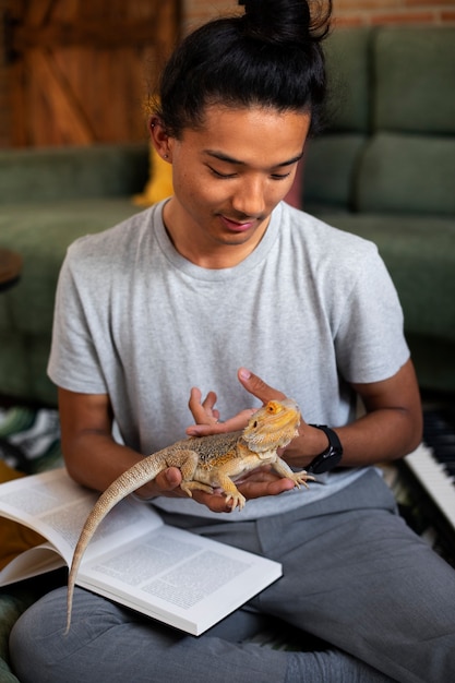 Foto gratuita adolescente de tiro medio con lagarto en casa.