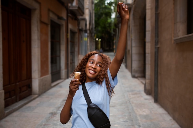 Foto gratuita adolescente tomando un helado al aire libre y sonriendo