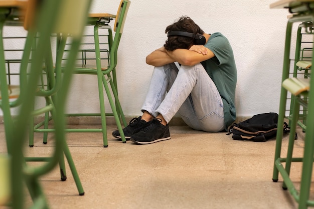 Adolescente triste de tiro completo en la escuela