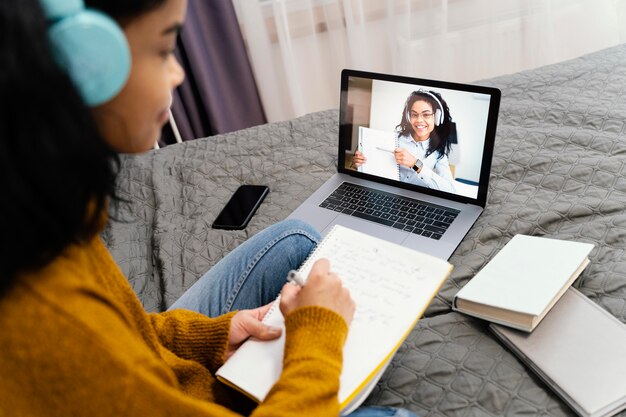 Adolescente usando laptop para escuela en línea