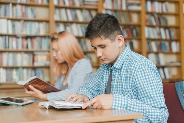 Adolescente varón estudiando cerca de amigo