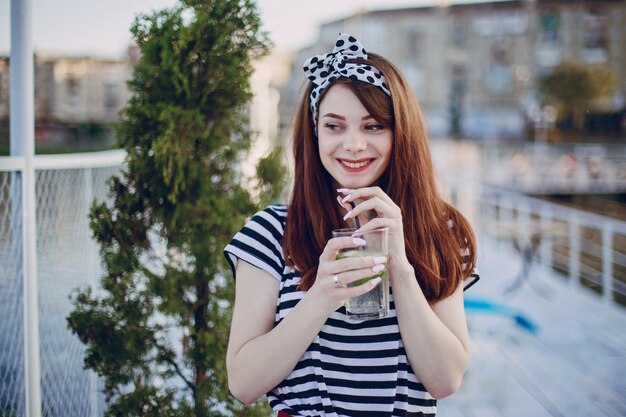 Adolescente con un vaso con una pajita y sonriendo