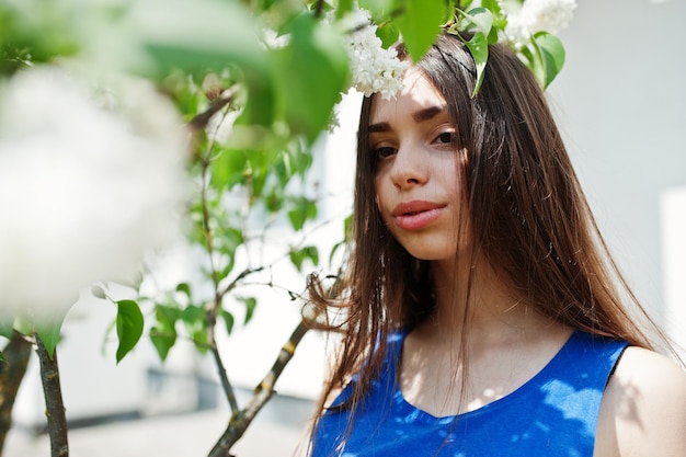 Adolescente en vestido azul posó al aire libre en un día soleado