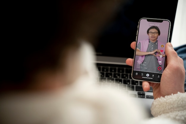 Adolescente viendo un video con su teléfono inteligente mientras está sentado en su cama