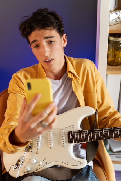 Adolescente de vista frontal haciendo música en casa