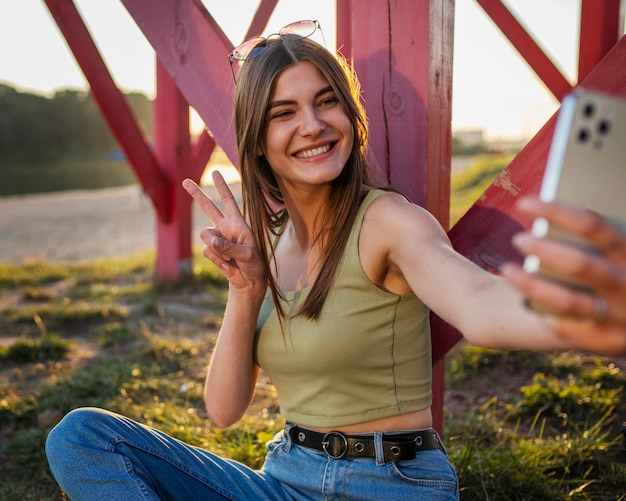 Foto gratuita adolescente de vista lateral con teléfono inteligente