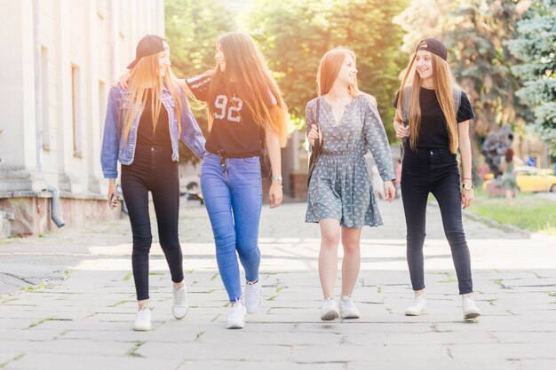 Adolescentes alegres caminando juntos después de la escuela