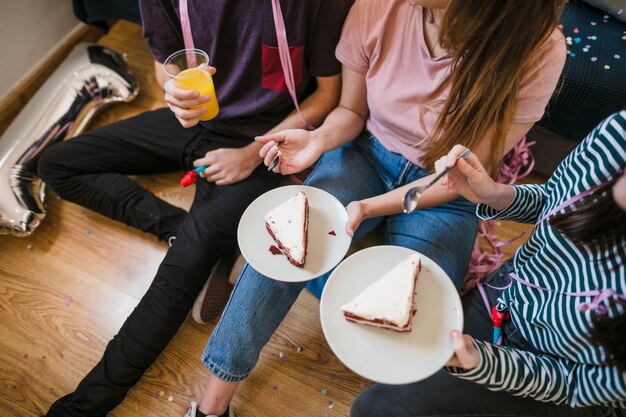 Adolescentes de alto ángulo comiendo pastel de queso