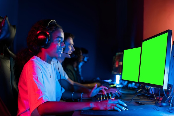 Foto gratuito adolescentes blancos y negras con auriculares jugando videojuegos en un club de juegos con iluminación azul y roja teclado y ratón con iluminación