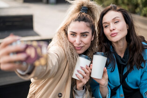 Adolescentes con estilo tomando una selfie al aire libre