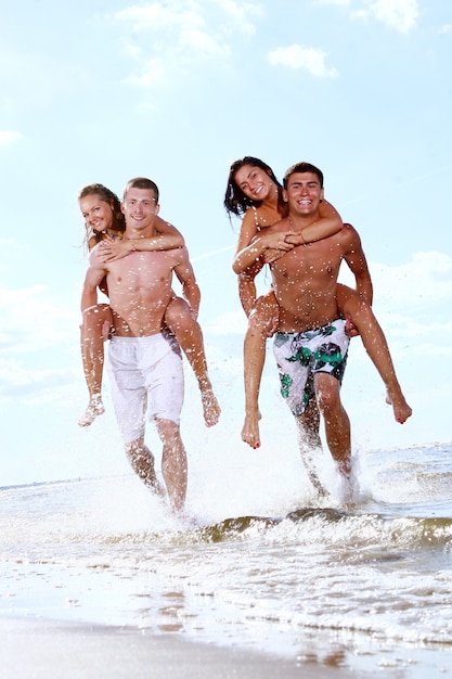 Adolescentes felices jugando en el mar