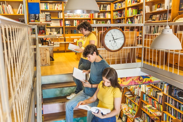 Foto gratuita adolescentes leyendo en la escalera cerca del reloj