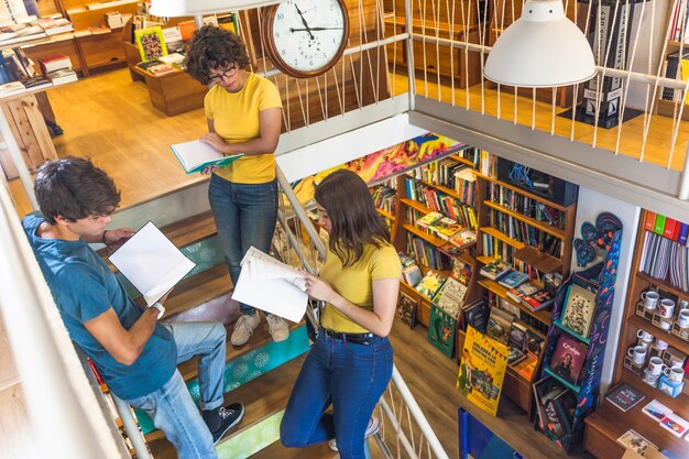 Adolescentes leyendo libros de texto en la escalera