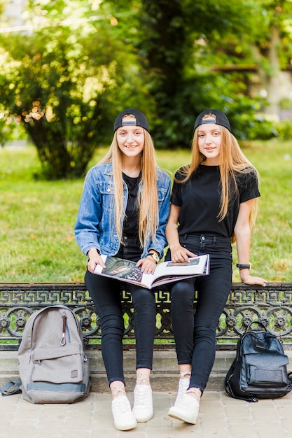 Las adolescentes con el libro que mira la cámara