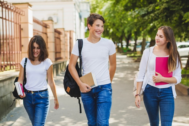 Adolescentes con libros de texto en la calle