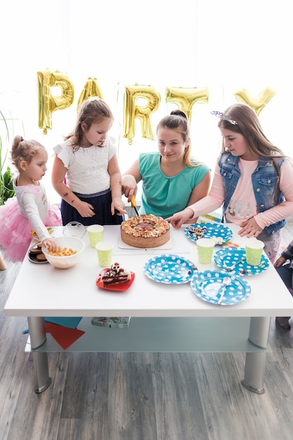 Foto gratuita adolescentes y niños cortando pastel