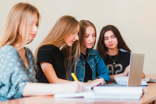 Adolescentes que usan la computadora portátil en la escuela