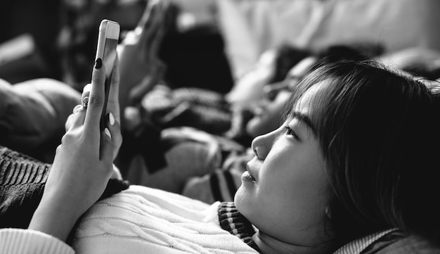 Adolescentes que usan teléfonos inteligentes en una cama de internet en la fiesta de pijamas