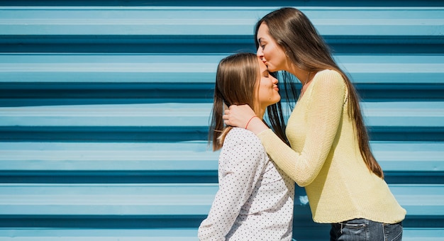 Adolescentes reflejando madre besando foto hija