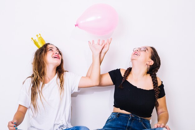 Adolescentes sentadas jugando con globos