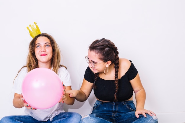 Adolescentes sentadas jugando con globos