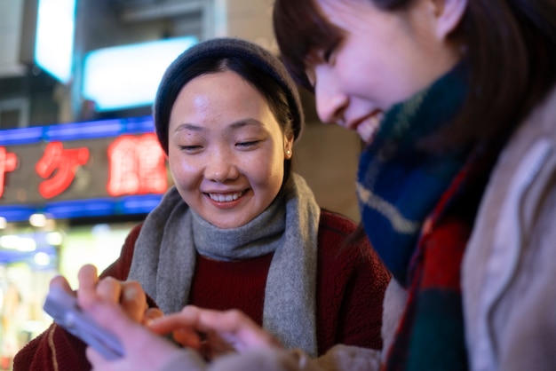 Adolescentes sonrientes que miran smartphone