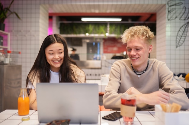 Adolescentes sonrientes de tiro medio con portátil