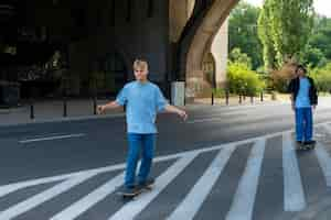 Foto gratuita adolescentes de tiro completo en patinetas al aire libre