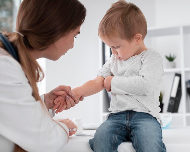 Adorable bebé esperando ser revisado por un médico