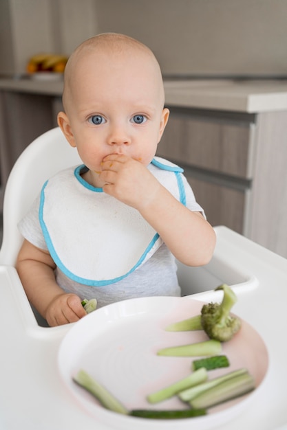 Foto gratuita adorable bebé jugando con comida