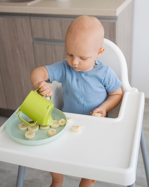 Foto gratuita adorable bebé jugando con comida