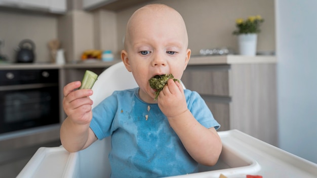 Foto gratuita adorable bebé jugando con comida