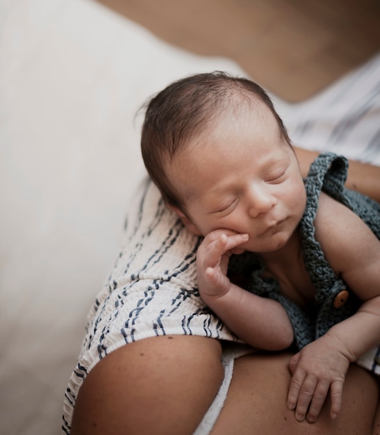 Foto gratuita adorable bebé en manos de la madre