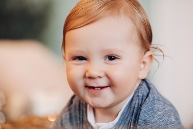 Adorable bebé sonriendo a la cámara. fondo borroso.