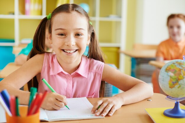 Adorable chica sonriendo en una clase