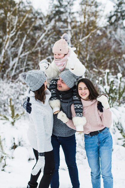 Adorable familia en el bosque de invierno