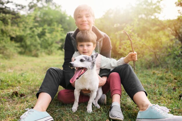 Adorable familia disfrutando el tiempo afuera con perro