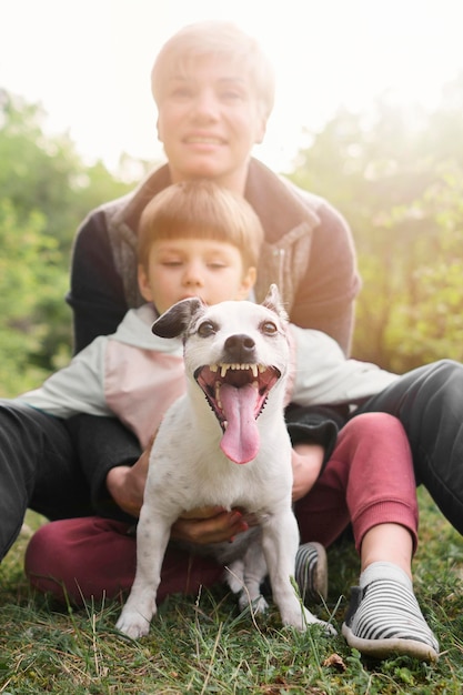 Foto gratuita adorable familia jugando con perro en el parque