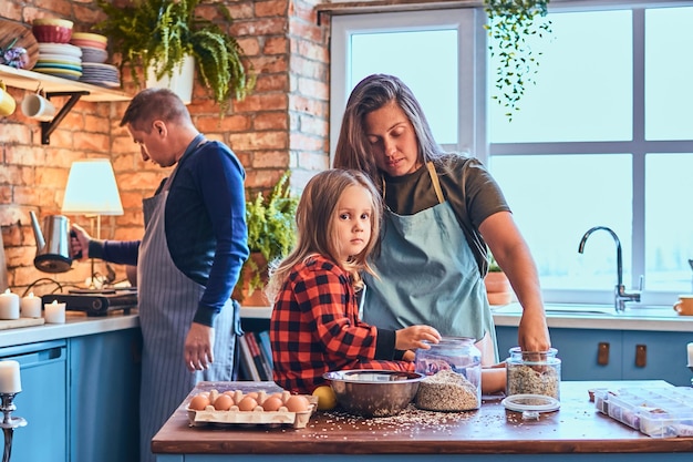 Adorable familia juntos cocinando el desayuno en la cocina estilo loft.