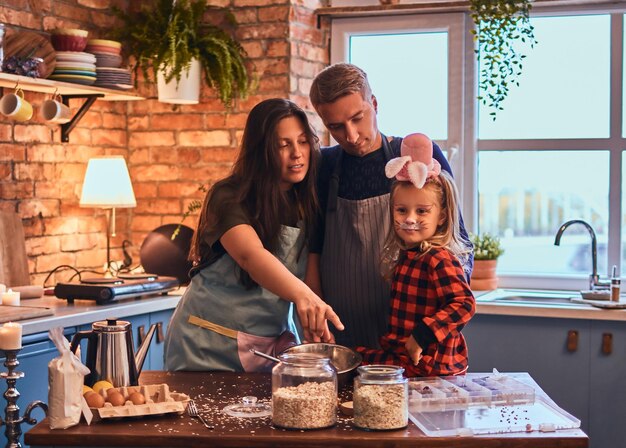 Adorable familia juntos cocinando el desayuno en la cocina estilo loft.