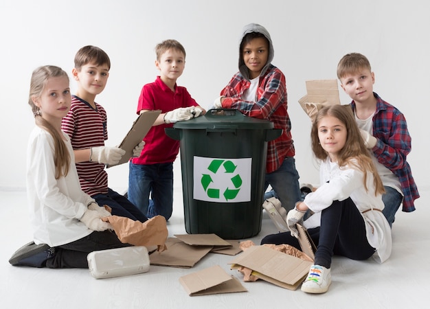 Foto gratuita adorable grupo de niños reciclando juntos