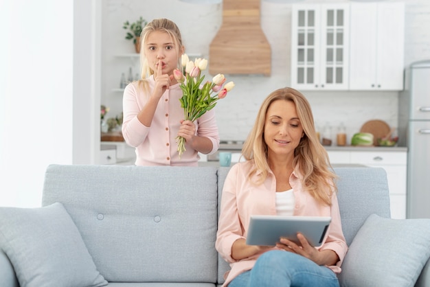 Foto gratuita adorable hija ofreciendo flores a su madre