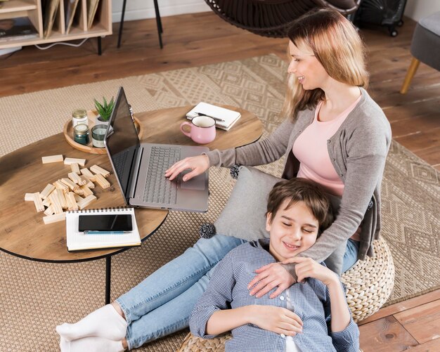 Adorable hijo está feliz de que la madre esté trabajando desde casa