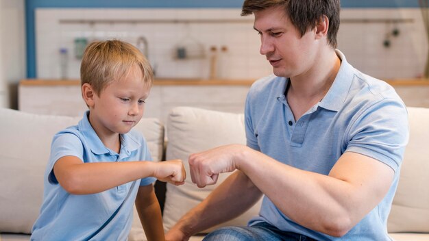 Adorable hijo jugando con el padre en casa