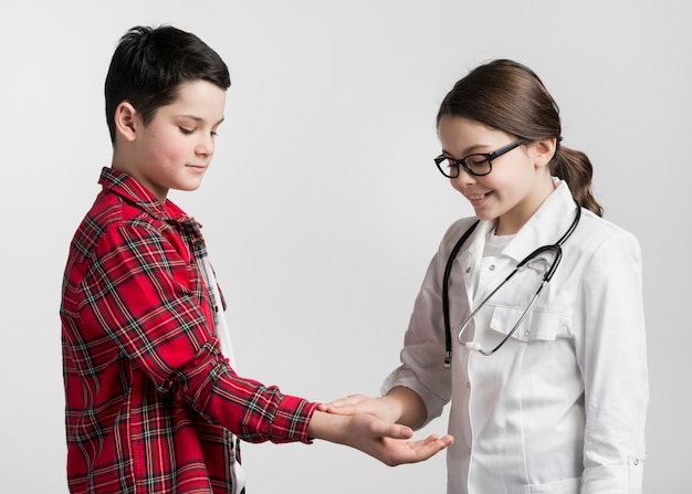 Adorable joven médico revisando la salud de los niños