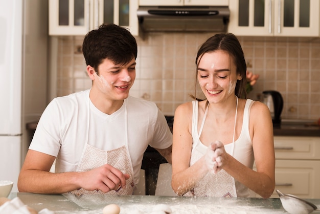 Foto gratuita adorable joven y mujer cocinando juntos