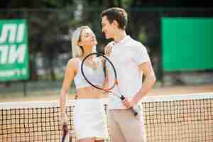 Foto gratuita adorable joven pareja en la cancha de tenis